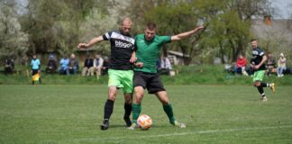 Two male soccer players in action during an outdoor match, showcasing competitive play.