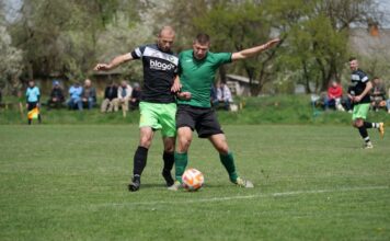Two male soccer players in action during an outdoor match, showcasing competitive play.