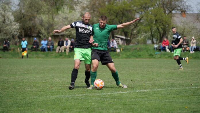 Two male soccer players in action during an outdoor match, showcasing competitive play.