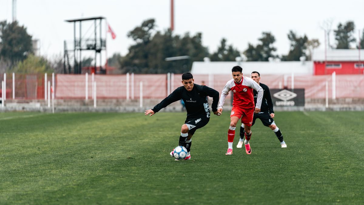 Three soccer players competing intensely on a grassy outdoor field. Three soccer players competing intensely on a grassy outdoor field.
