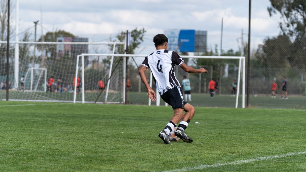 Youth soccer player wearing number 6 in striped jersey, playing outdoors. Youth soccer player wearing number 6 in striped jersey, playing outdoors.