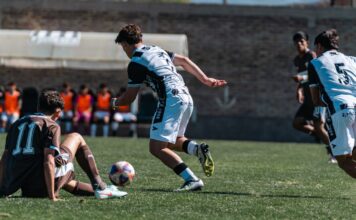 Intense moment captured during a youth soccer match outdoors, showcasing teamwork and competition.