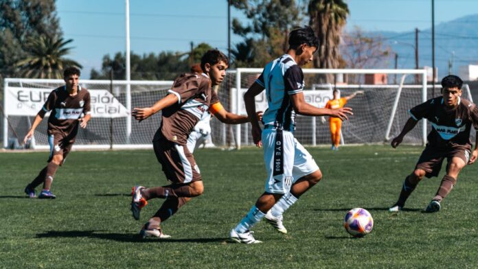 Intense moment during a youth soccer match with players in motion on a sunny day.