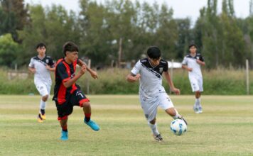 Boys passionately engaging in a competitive outdoor soccer game on a grassy field.