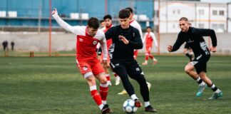 Dynamic soccer match capture with competing players striving for the ball outdoors.