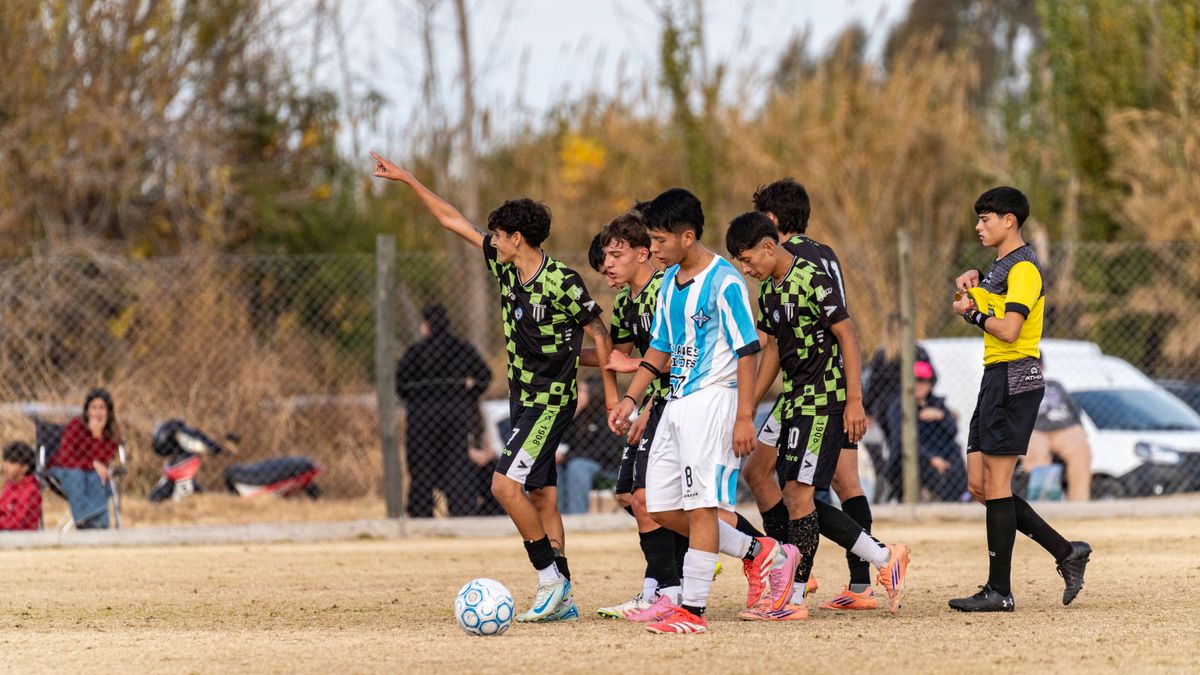 Youth soccer players and referee during a match on a grass field, showcasing teamwork. Youth soccer players and referee during a match on a grass field, showcasing teamwork.