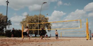 Group of men playing beach volleyball on a sunny day in Jönköping, Sweden.