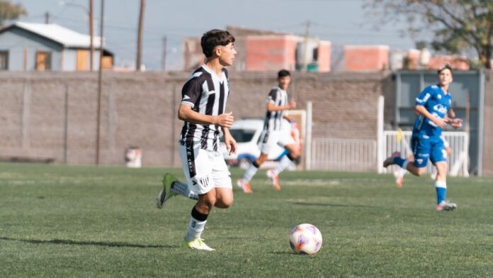 Teenage soccer players in action during a match on an outdoor field under daylight. Teenage soccer players in action during a match on an outdoor field under daylight.