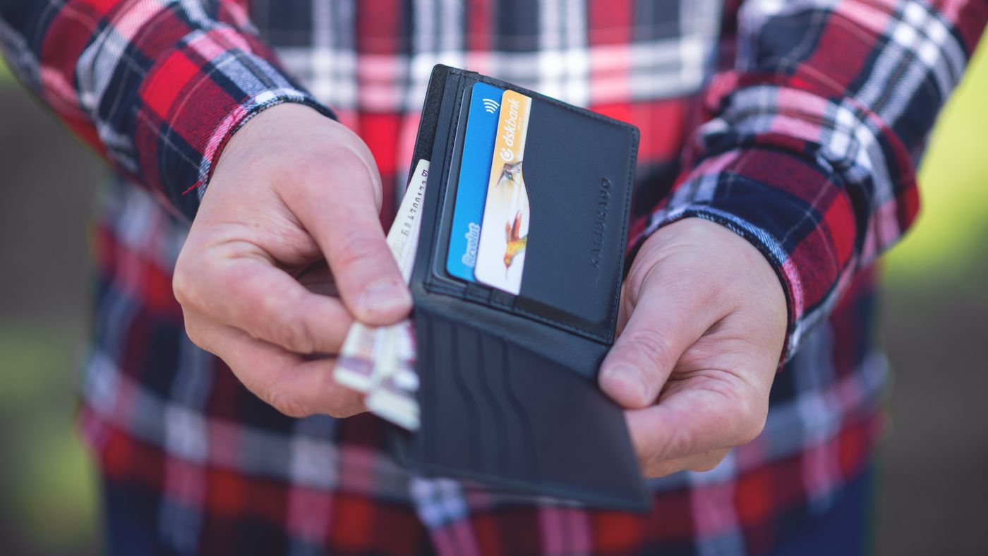 Primo piano di mani che aprono un portafoglio con carte di credito