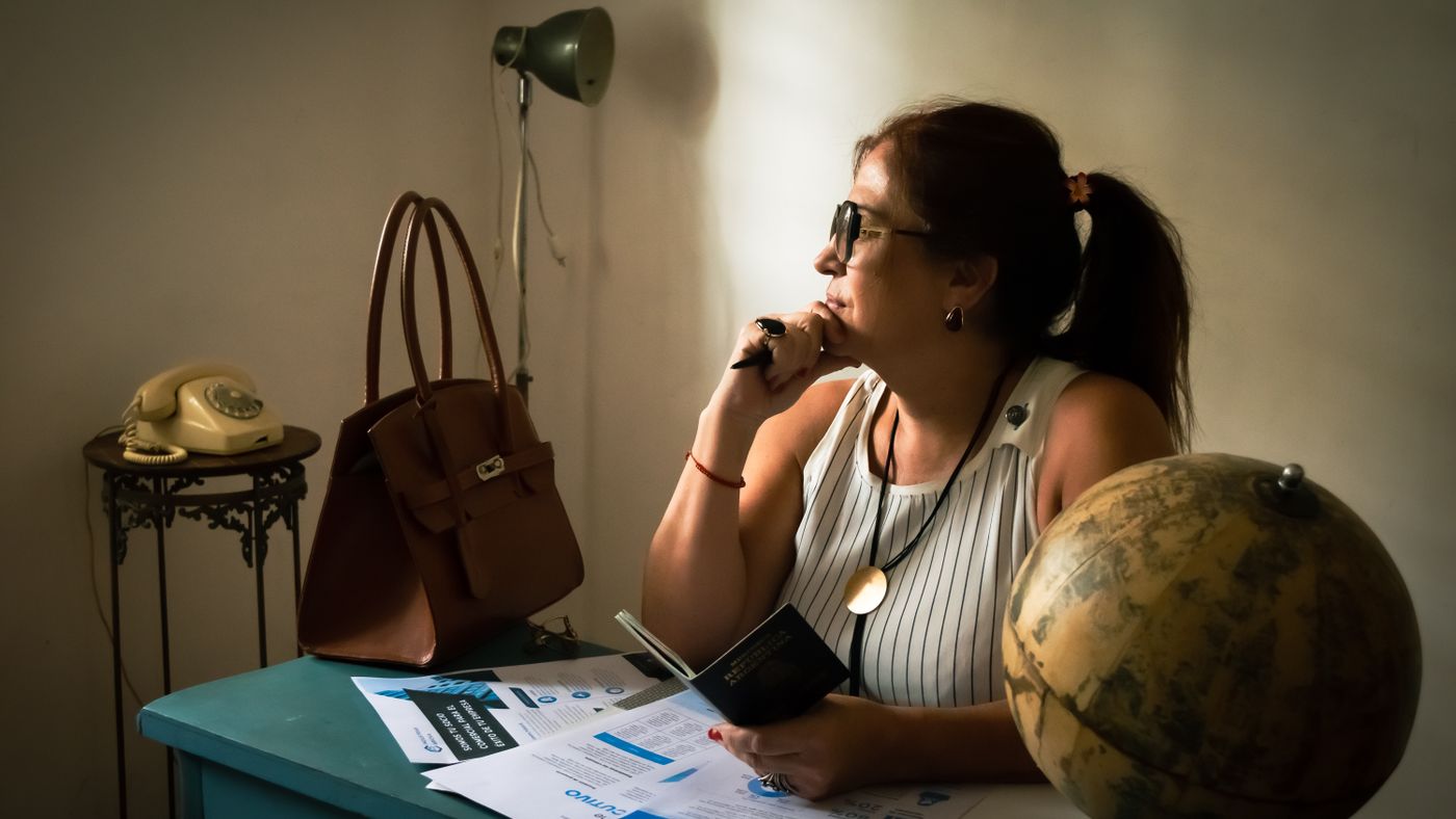Donna in ufficio vintage riflette con un globo e documenti
