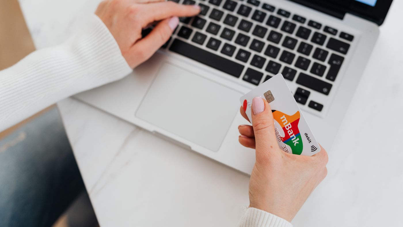 Primo piano di una persona con laptop e carta di credito per shopping online