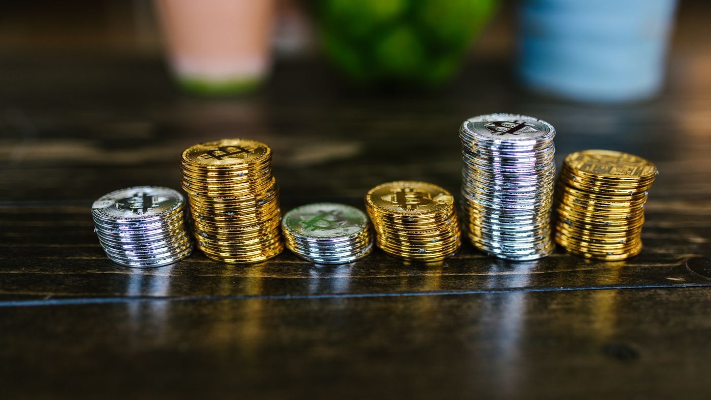 Mucchio di monete crypto dorate e argentate su un tavolo di legno