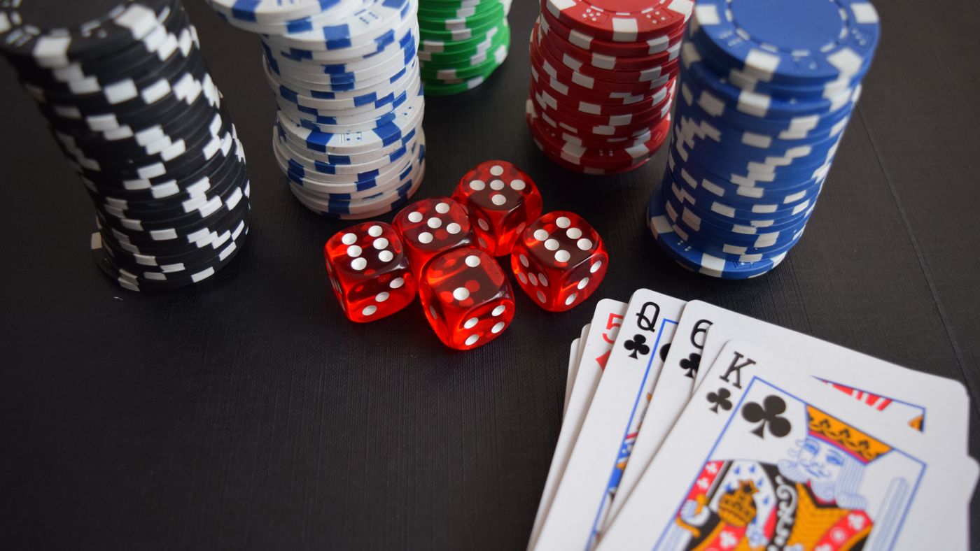 Fiches, dadi e carte da gioco su un tavolo di un casino online