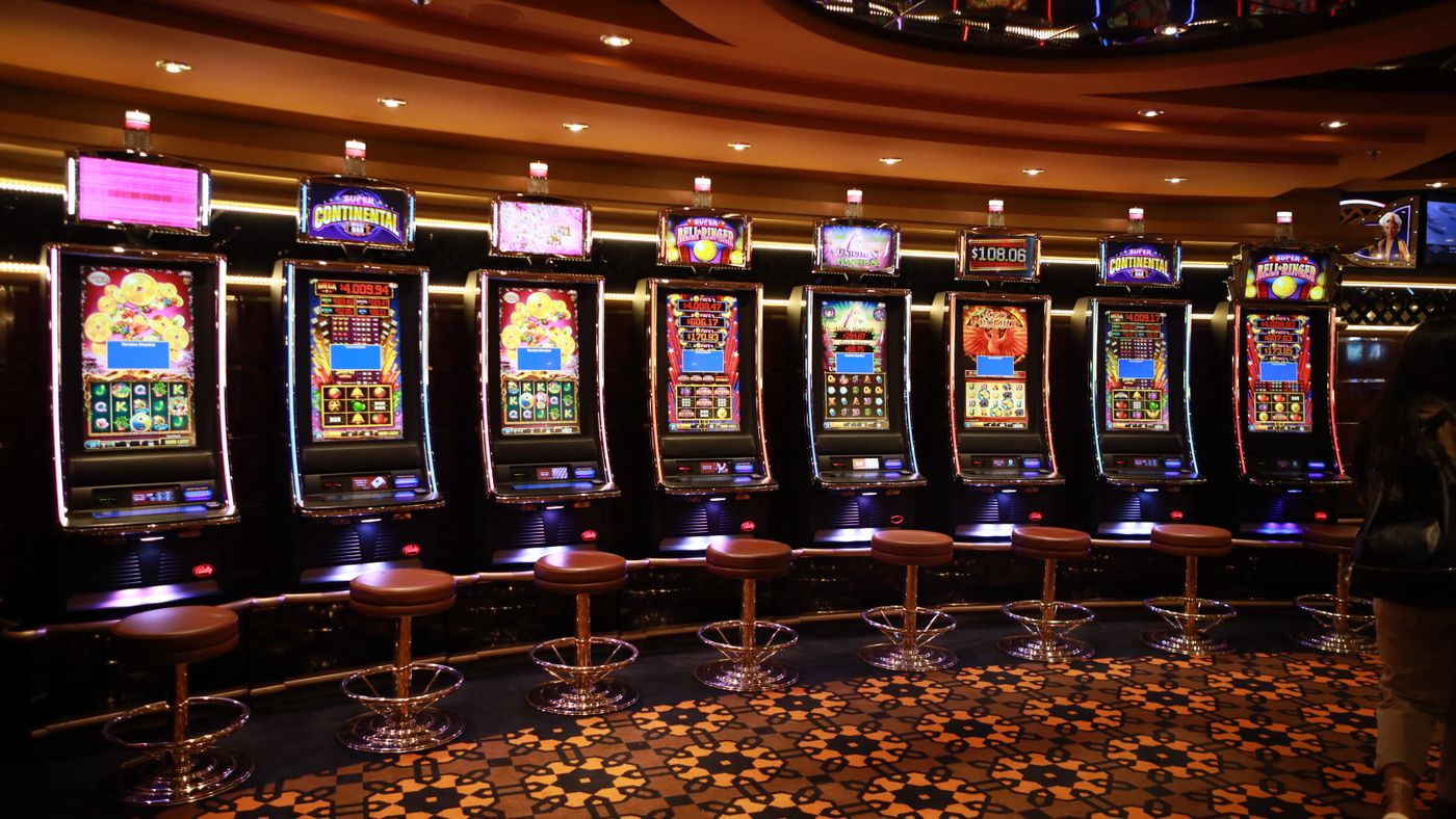 Fila di slot machine di lusso con sgabelli imbottiti in un casinò