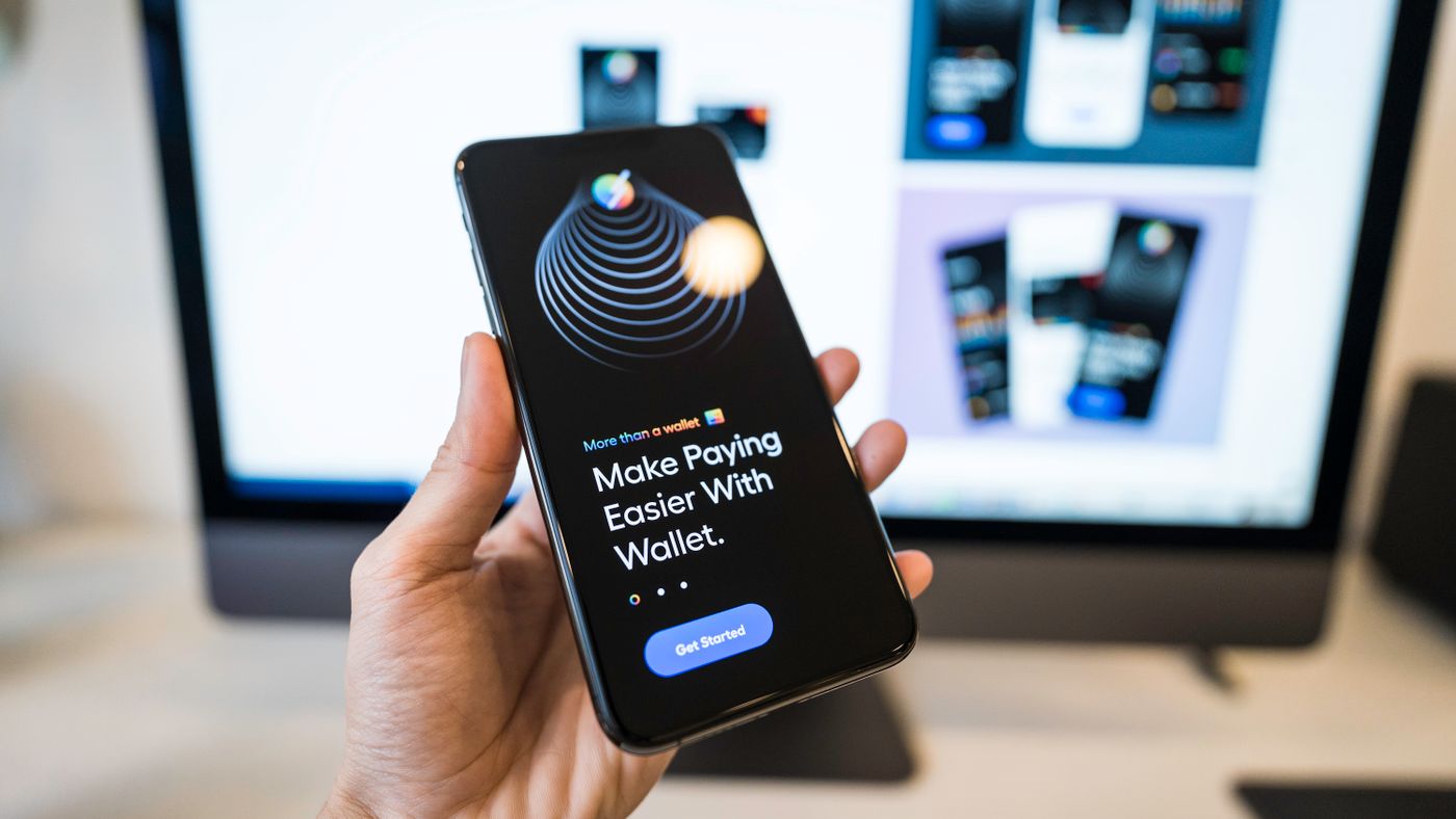 Mano con smartphone che mostra un'app di portafoglio digitale