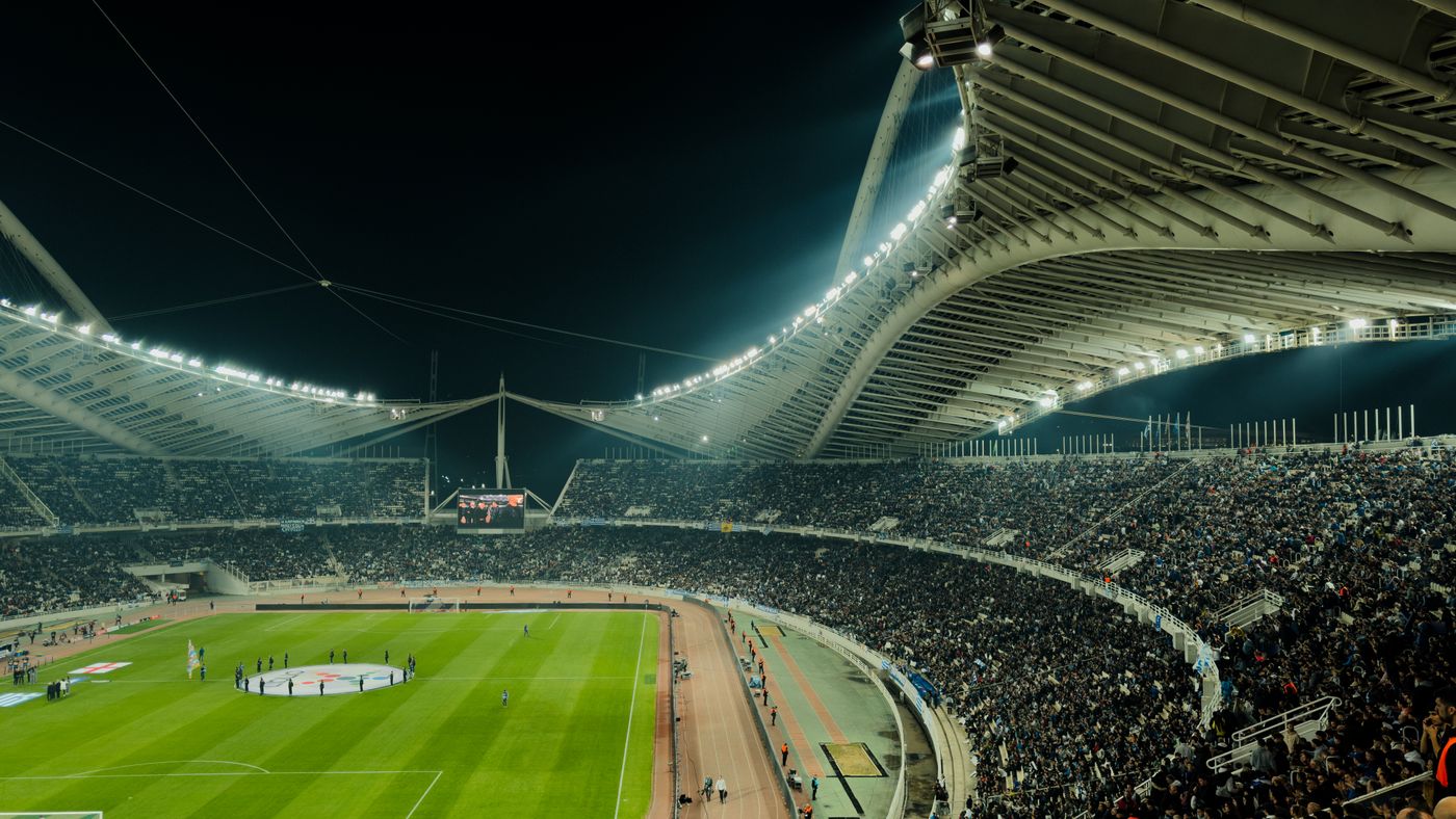 Stadio di calcio affollato sotto le luci notturne durante una partita