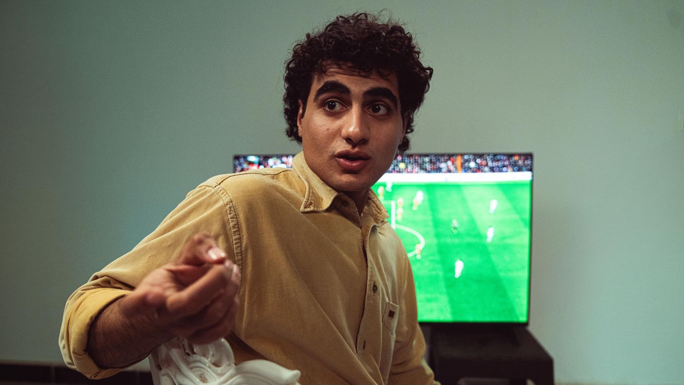 Uomo che guarda una partita di calcio in TV con emozione